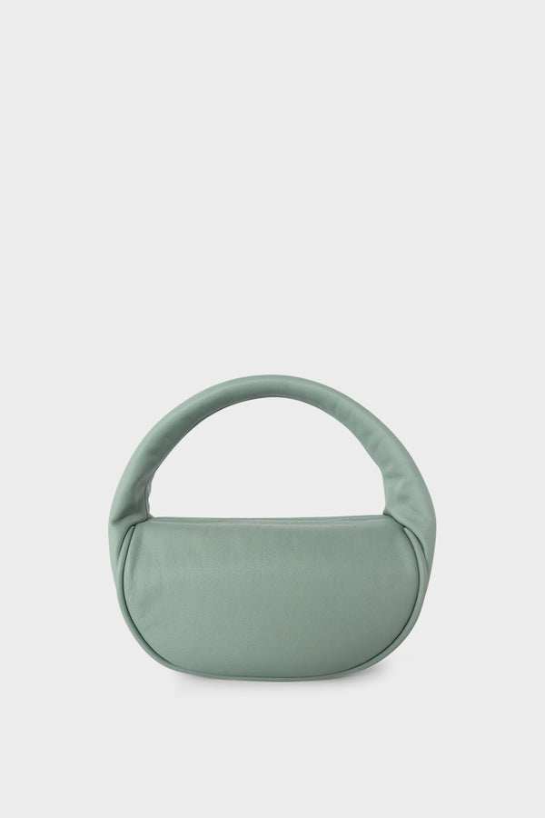 A pastel green mini bag. This handbag is similar to a clutch but with one handle connecting its body. It’s made of Italian grain leather.