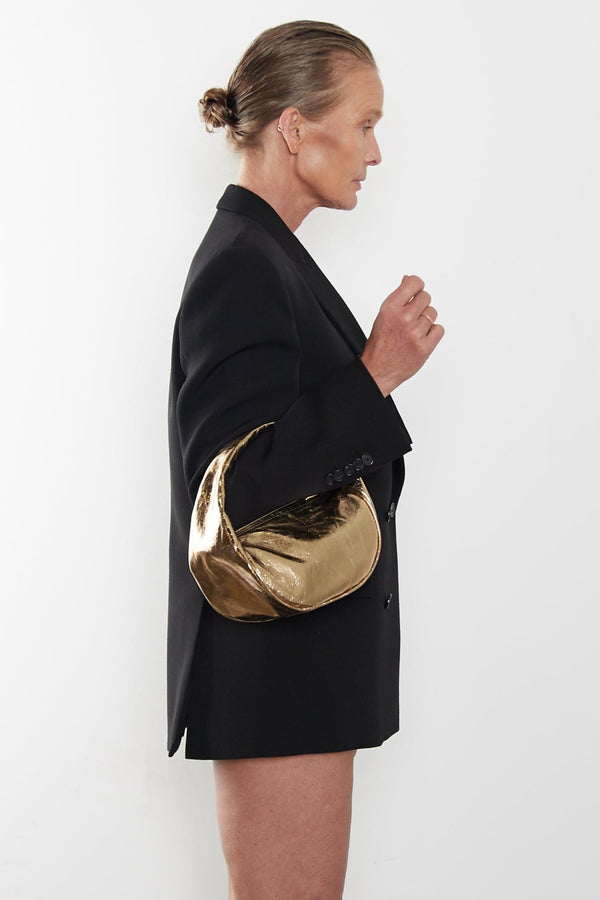 A woman carrying the mini halo bag in the crook of her arm. This handbag can be carried as a clutch or a purse during parties and events.