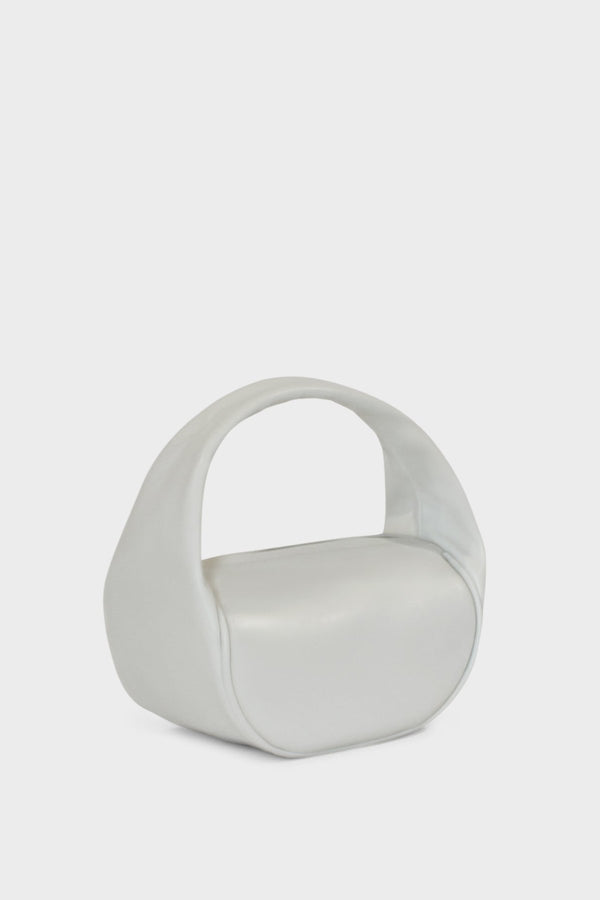 An angled image of the mini bag featuring its U-shaped petite and structured body connected by a single handle to carry as a purse or clutch.