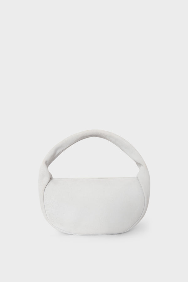 A white suede mini bag. This handbag is similar to a clutch but with one handle connecting its body. It’s made Italian leather.