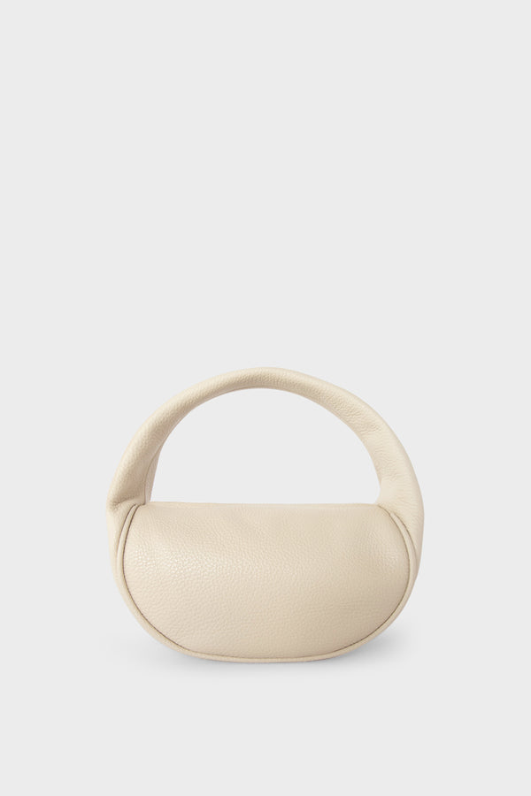 A white mini bag. This handbag is similar to a clutch but with one handle connecting its body. It’s made of Italian grain leather.