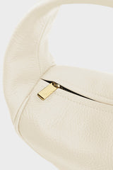 The white mini halo bag features gold hardware and durable zippers with the initial “A” engraved for A-esque.