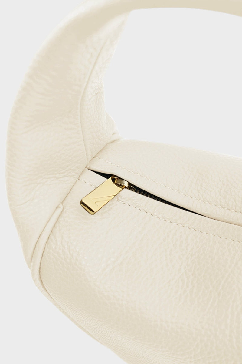 The white mini halo bag features gold hardware and durable zippers with the initial “A” engraved for A-esque.