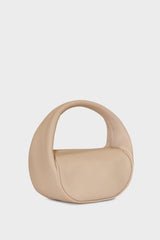 A side image of the mini halo bag in pastel pink.  This handbag has a clutch like design and can be worn handheld or on the crook of the arm suited as a party or evening purse.