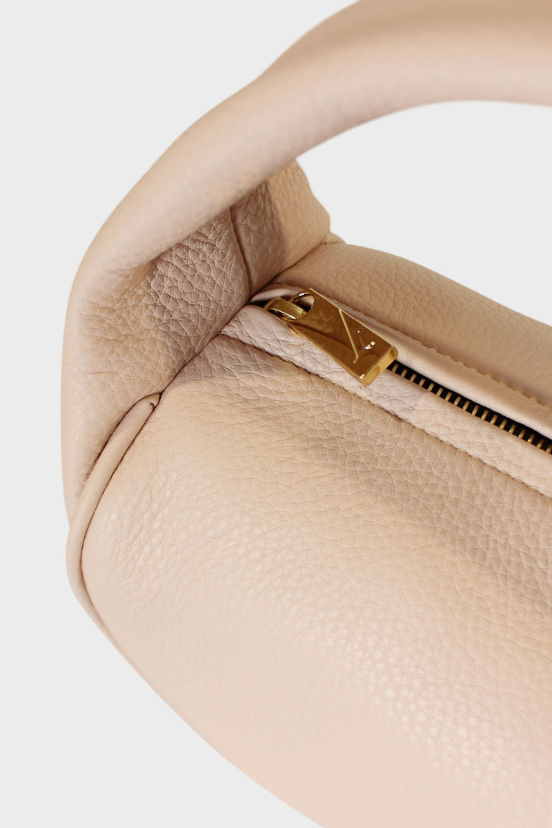 The mini halo bag features a gold hardware and durable zippers. This image features the mini bag's zipper with the initial A which stands for A-esque, the brand's name.