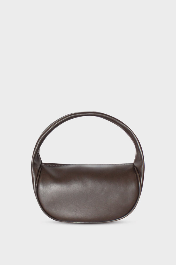 A dark brown mini bag. This handbag is similar to a clutch but with one handle connecting its body. It’s made of smooth Italian leather.