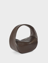 A side image of the mini halo bag in dark brown.  This handbag has a clutch like design and can be worn handheld or on the crook of the arm suited as a party or evening purse.