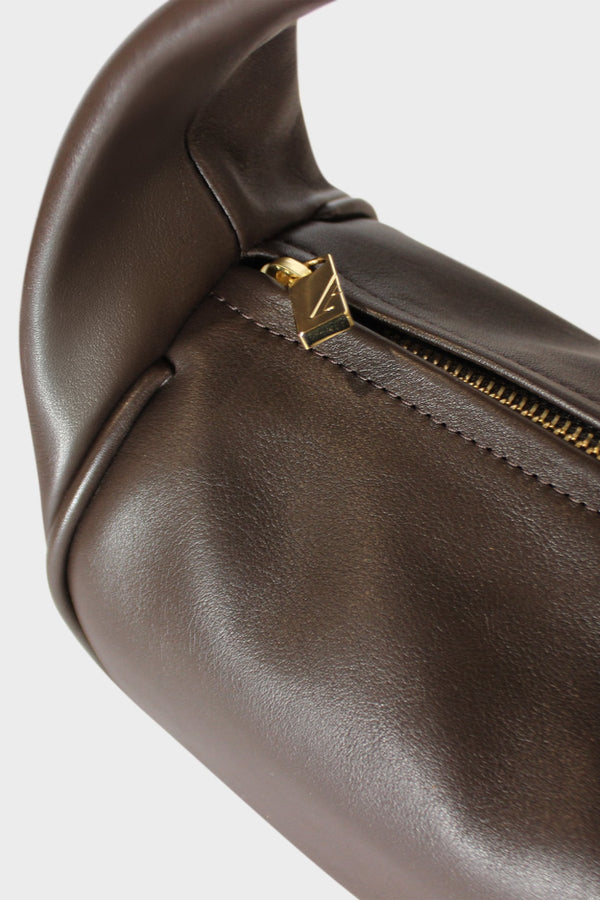 The dark brown halo bag features gold hardware and a durable zipper with the initial “A” engraved for A-esque.