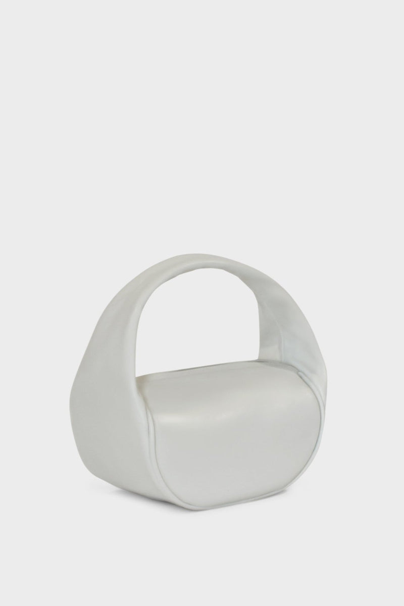 A side image of the mini halo bag in off white.  This handbag has a clutch like design and can be worn handheld or on the crook of the arm suited as a party or evening purse.