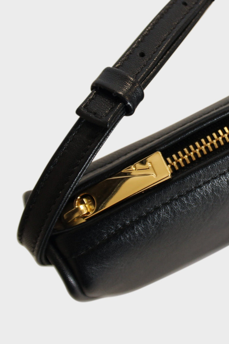 The mini saddle shoulder bag features a gold hardware and zippers. This image features the mini bag's zipper with the initial A which stands for A-esque, the brand's name.