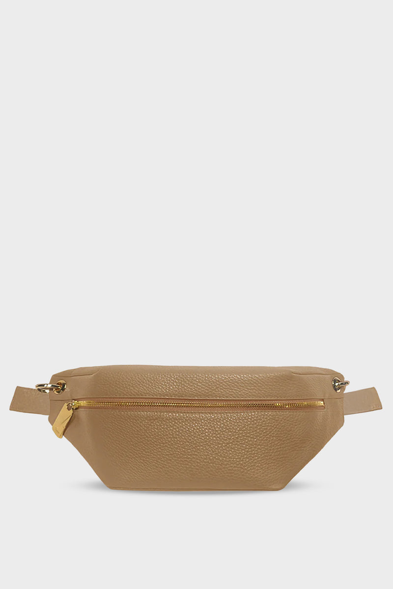 A beige crossbody bag that also takes the form of a belt bag. It has a zip opening in gold hardware and is made of fine Italian grain leather. 