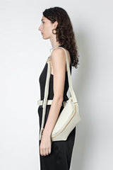 The oblong bum bag slung in the shoulder as a shoulder bag.