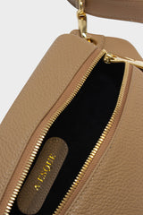 The oblong crossbody bag's interior is lined in suede with an embossed A-esque logo in the middle.