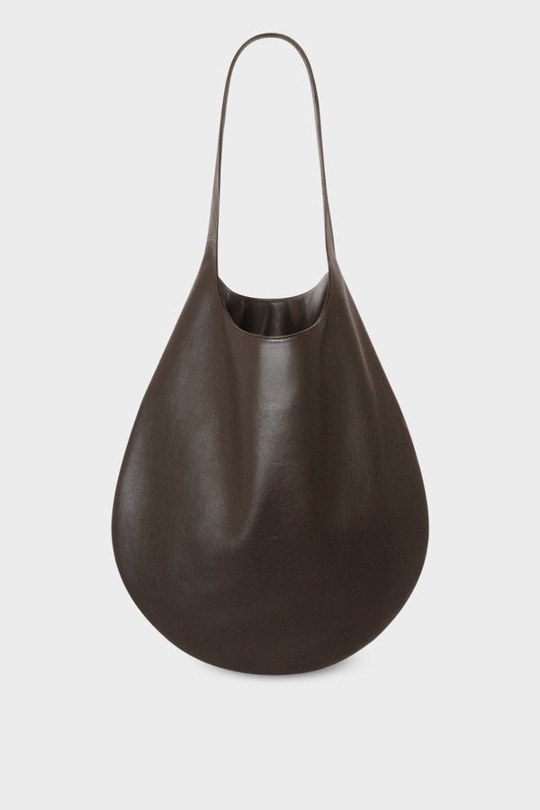 A slim hobo bag in burgundy. Worn as a shoulder bag or carried handheld, the bag has a magnetic closure and is made of fine Italian grain leather.