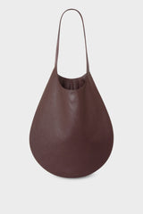 A slim hobo bag in burgundy. Worn as a shoulder bag or carried handheld, the bag has a magnetic closure and is made of fine Italian grain leather.