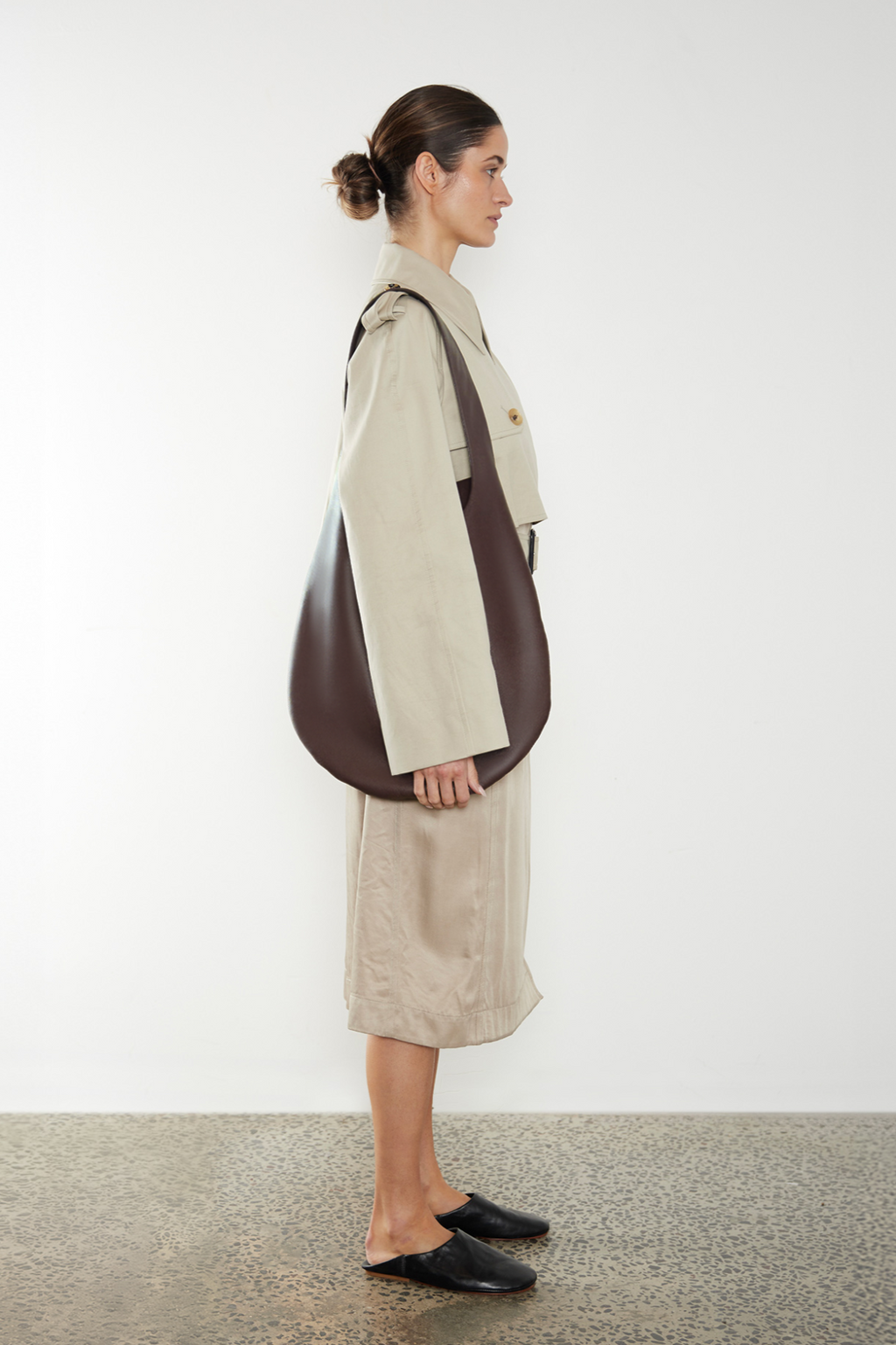 A woman carrying the One Hobo shoulder bag. It shows a front angle of the hobo showcasing its soft slouch in the bag's body. It can carry everyday essentials and can be used as a work bag or a travel bag.
