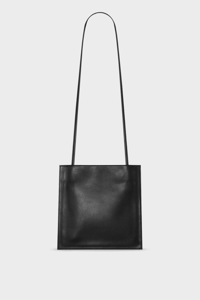 A black mini crossbody bag with a slim pouch design. It features a thin adjustable leather strap that can transition as a shoulder bag.