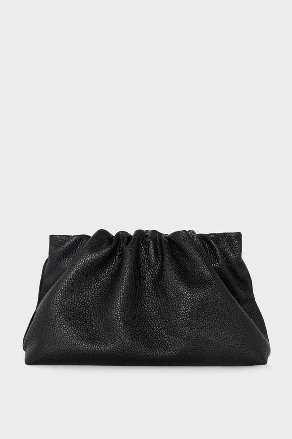 A black clutch bag made of grain Italian leather. The handbag has a removable strap and can also be worn as a crossbody bag.