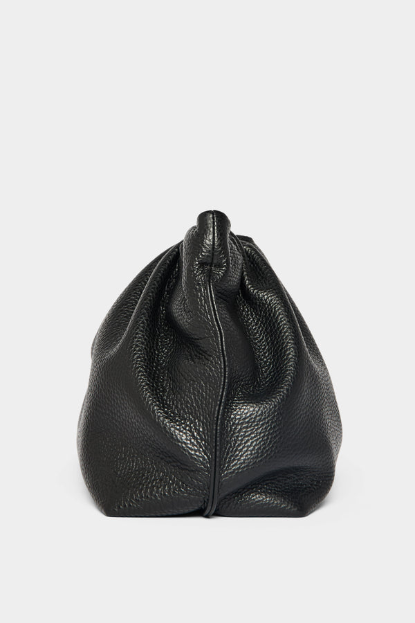 A side angle of the Puffa clutch purse featuring a delicate hand stitching of the mini bag's sides. 