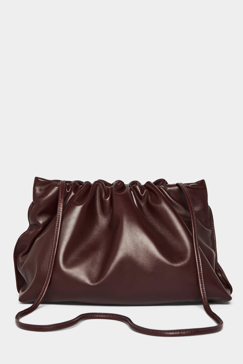 A burgundy clutch bag with a long removable shoulder strap. The handbag can also be worn handheld or a crossbody bag. 