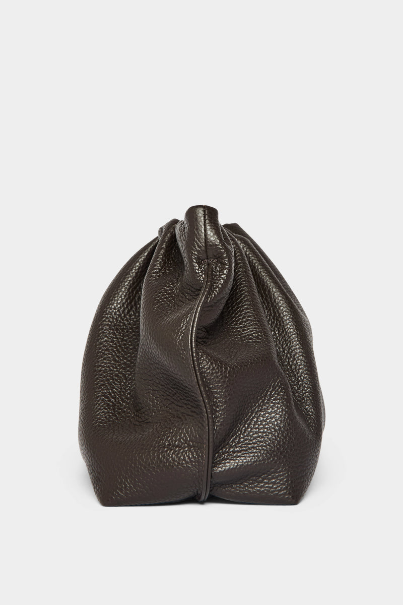 A side angle of the Puffa clutch purse featuring a delicate hand stitching of the mini bag's sides. 