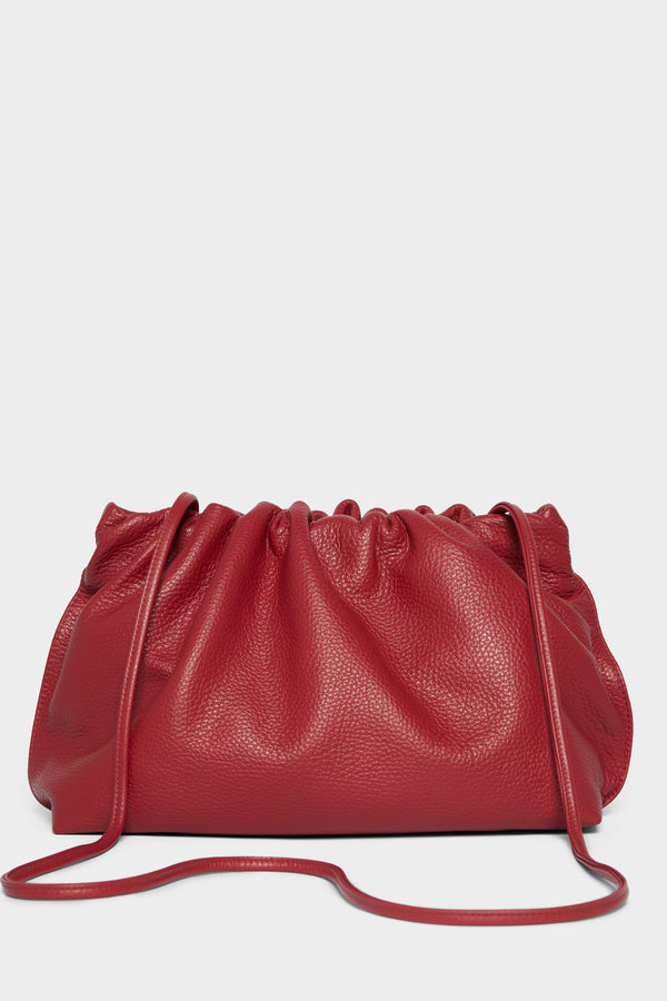 A red clutch bag with a long removable shoulder strap. The handbag can also be worn handheld or a crossbody bag. 