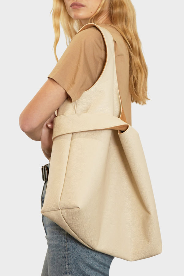 A woman carrying the tote bag on her shoulder.  The tote shoulder bag is suited as an everyday work bag.