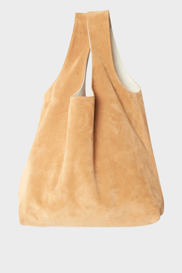 The reversible sack tote bag has two sides. One is white grain leather. This image shows the reversed suede brown side of the tote.