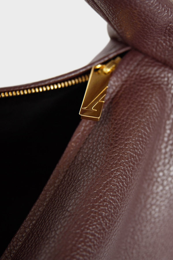 The Slimline Halo shoulder bag features gold hardware and a durable zipper with the initial “A” engraved for A-esque.