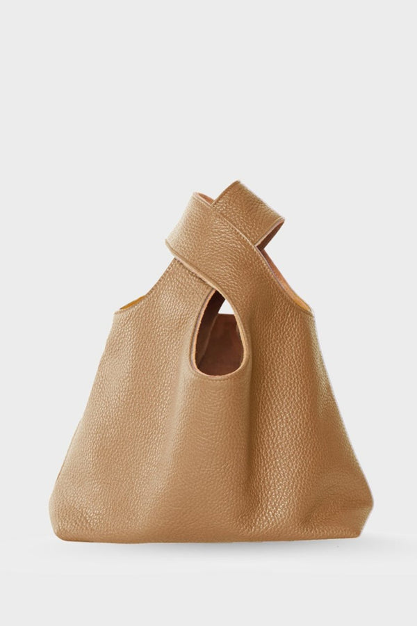 A small beige handbag made of fine Italian grain leather. This mini bag is suited to carry as a clutch for casual events. 