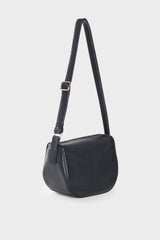 A side angle of black crossbody bag made of fine smooth Italian leather. The bag follows a satchel like design, it is midsized with a structured body. The bag can carry everyday essentials and can be used as a womens work bag.