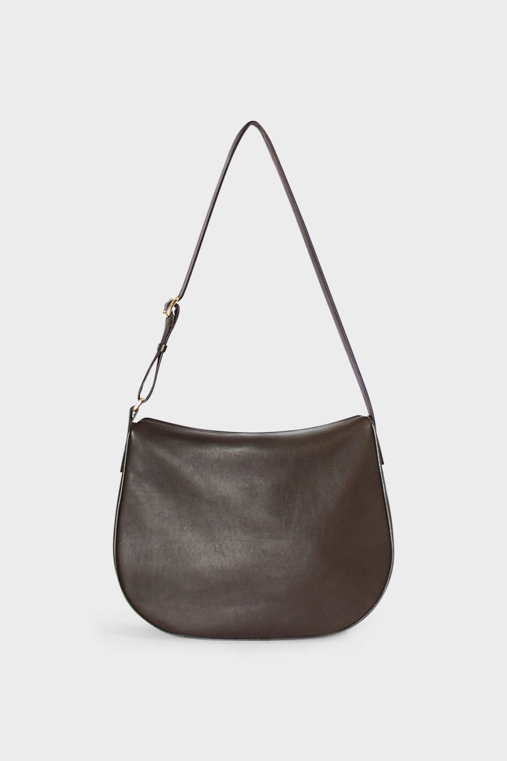 A dark brown crossbody bag made of fine smooth Italian leather. The crossbody bag follows a satchel like design, it is large but has a slim body. The bag can carry everyday essentials and can be used as a work bag or a travel bag. The bag is called Saddle Large Crossbody Bag in Smooth Dark Brown.