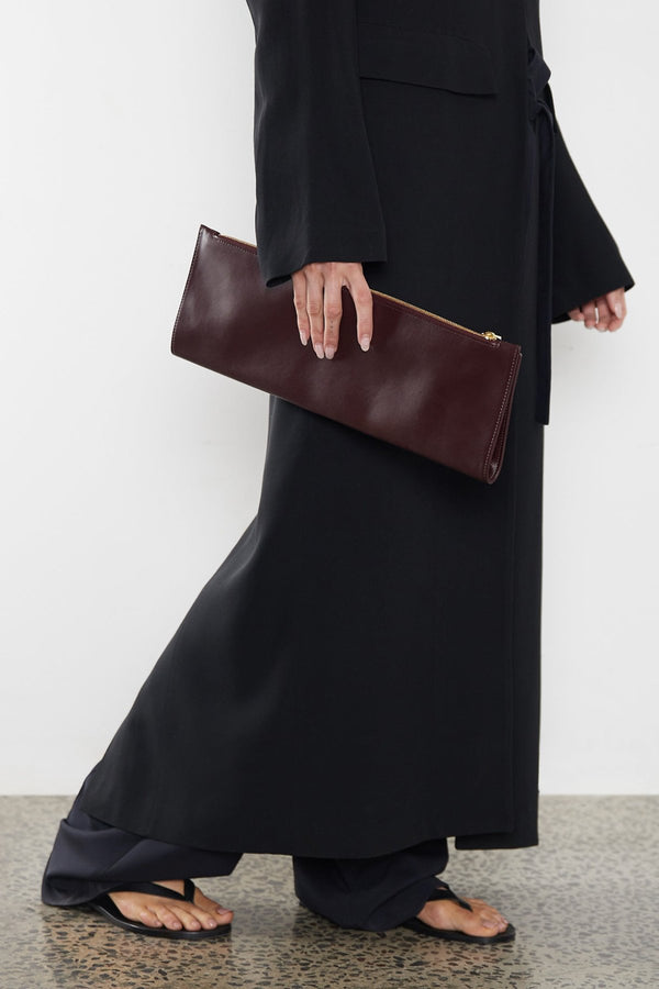 A woman carrying the slimline clutch pouch. 