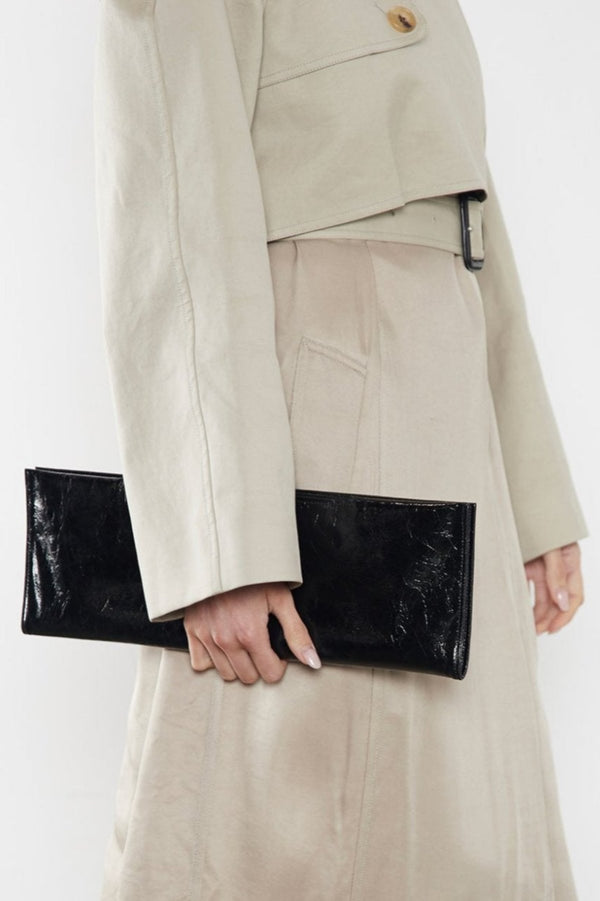 A woman carrying the slimline clutch pouch. The clutch when folded looks like a long wallet. 