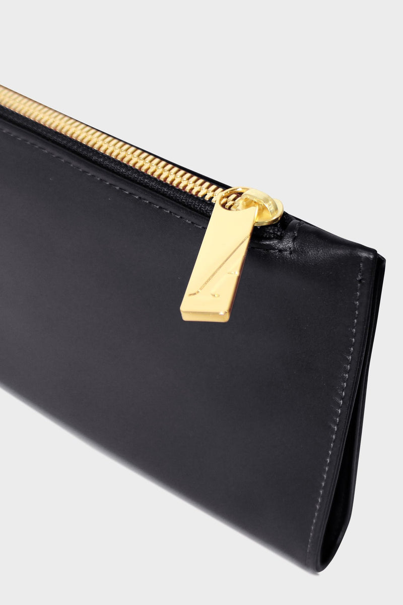 The slimline clutch pouch features a gold hardware and durable zipper and magnetic closures. This image features the clutch zipper with the initial A which stands for A-esque, the brand's name.