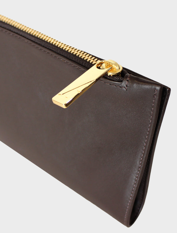 The slimline clutch pouch features a gold hardware and durable zipper and magnetic closures. This image features the clutch zipper with the initial A which stands for A-esque, the brand's name.