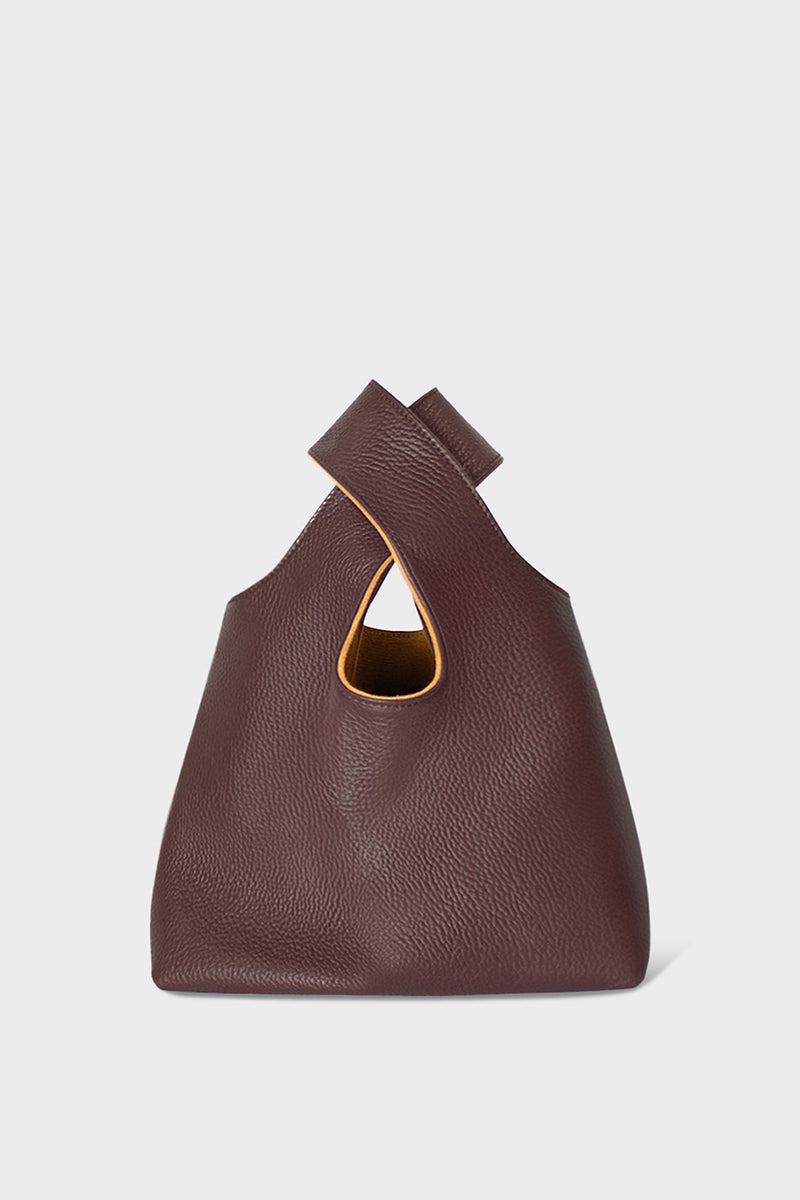 A small burgundy handbag made of fine Italian grain leather. This mini bag is suited to carry as a clutch for casual events. 