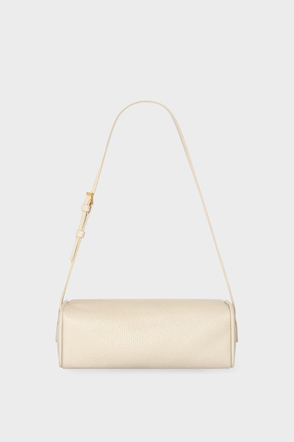 A small white shoulder bag made of grain Italian leather. The bag has a compact design and features an adjustable strap handle.