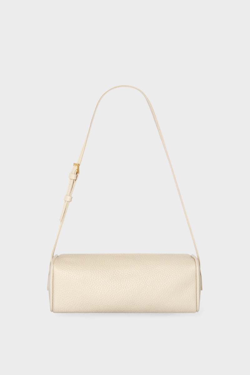 A small white shoulder bag made of grain Italian leather. The bag has a compact design and features an adjustable strap handle.