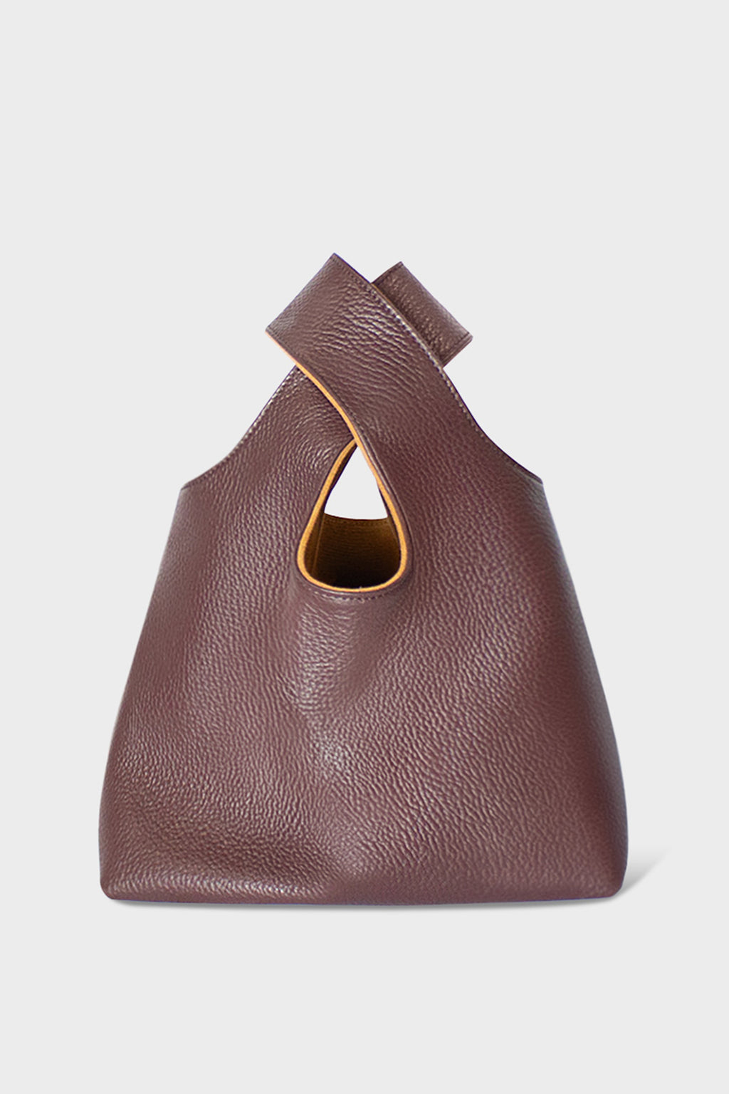 A small burgundy handbag made of fine Italian grain leather. This mini bag is suited to carry as a clutch for casual events.