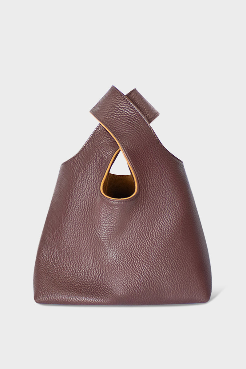 A small burgundy handbag made of fine Italian grain leather. This mini bag is suited to carry as a clutch for casual events.