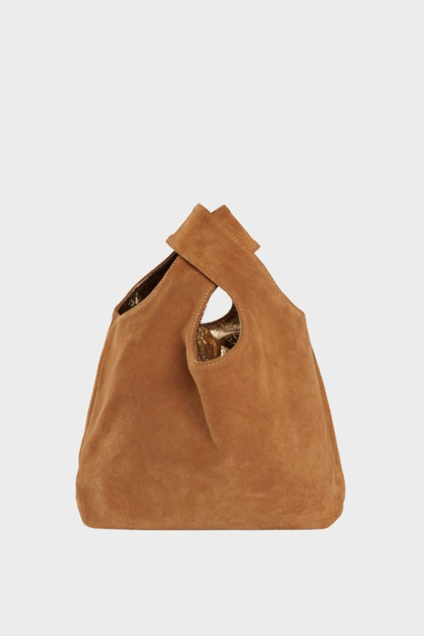 The suede side of the small reversible tote bag. The handbag is convertible to one side in metallic gold leather and the other in brown suede leather.