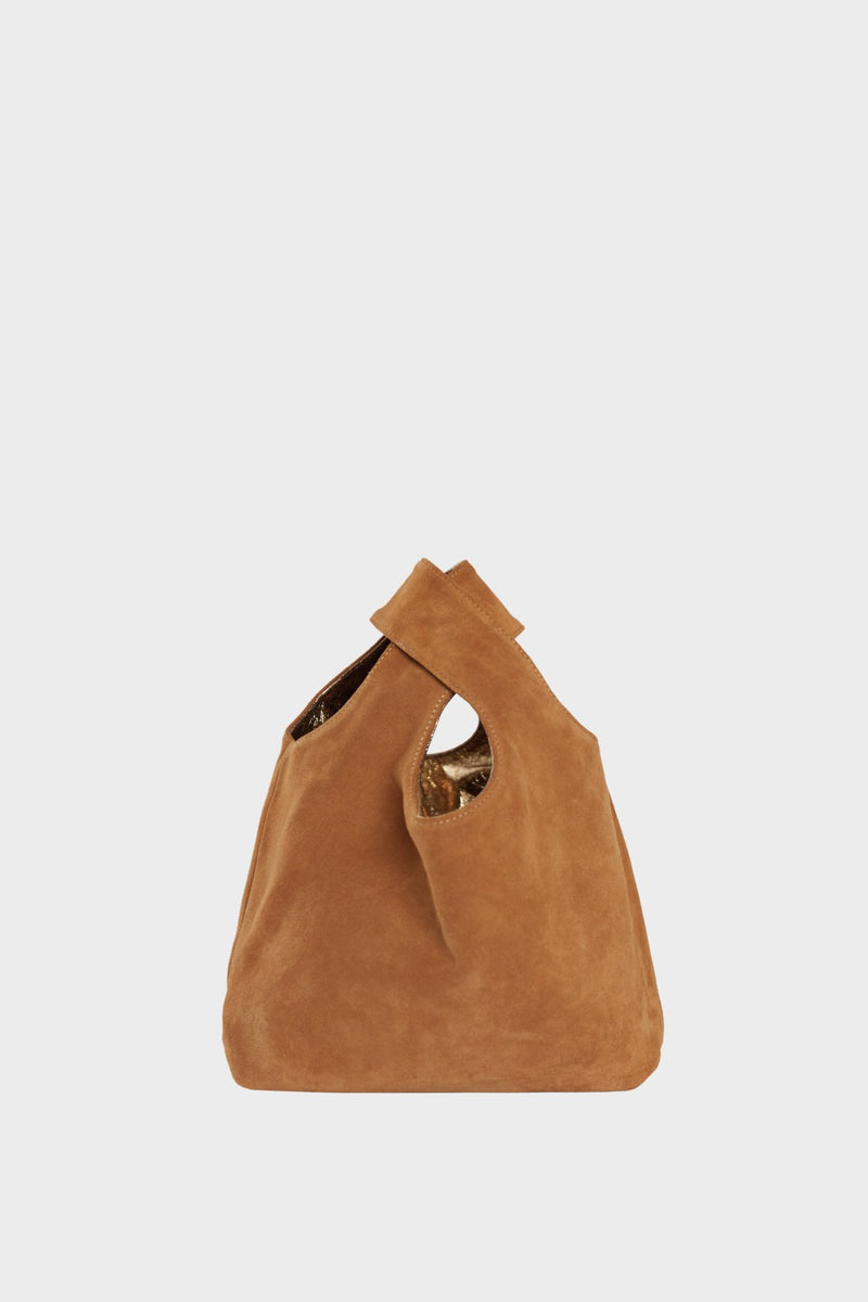 The suede side of the small reversible tote bag. The handbag is convertible to one side in metallic gold leather and the other in brown suede leather.