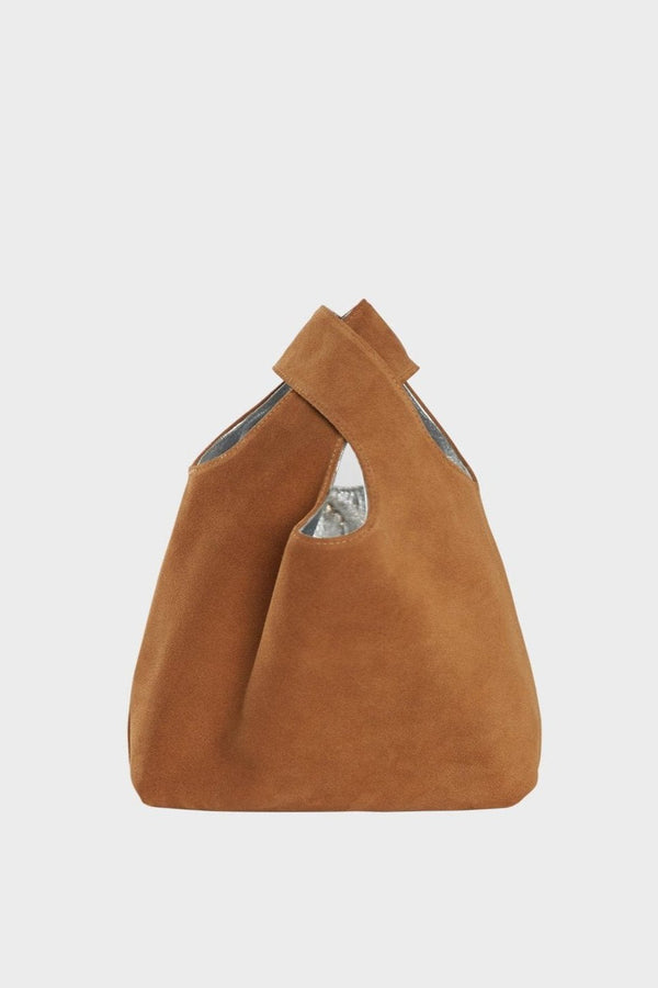 The suede side of the small reversible tote bag. The handbag is convertible to one side in metallic silver leather and the other in brown suede leather.