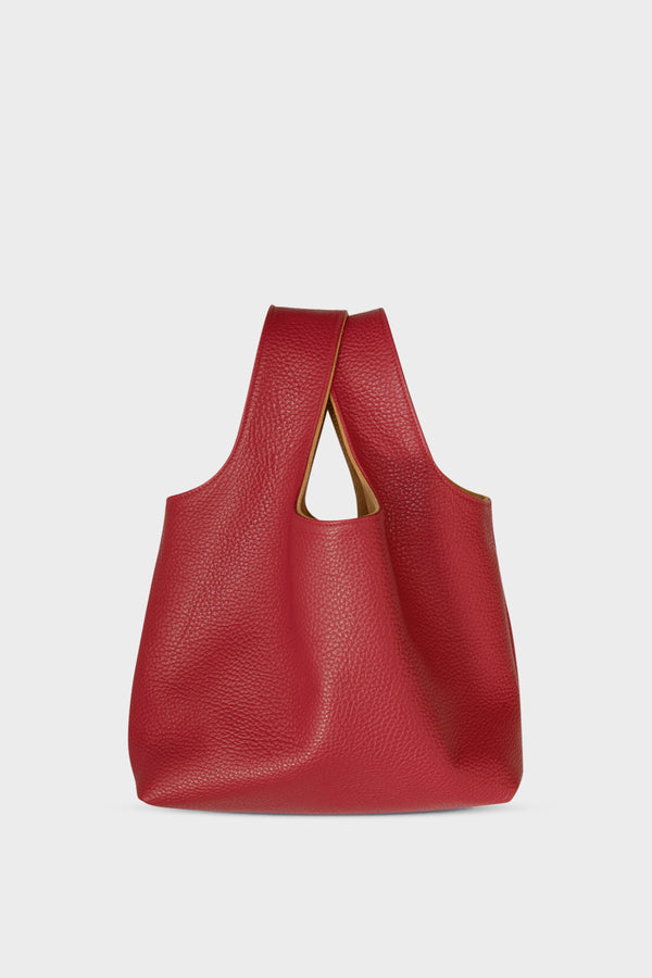 A small red handbag made of fine Italian grain leather. This mini bag is suited to carry as a clutch for casual events.