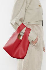 A woman carrying the small reversible handbag slung in the crook of the arm. This mini bag works well as an everyday purse.