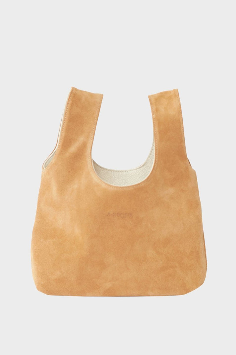 The suede side of the small reversible tote bag. The handbag is convertible to one side in white smooth leather and the other in brown suede leather.