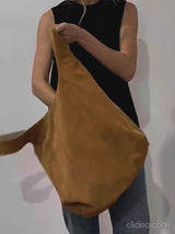 A video of a woman showing the reversible feature of the tote bag in its white grain leather and brown suede side. 