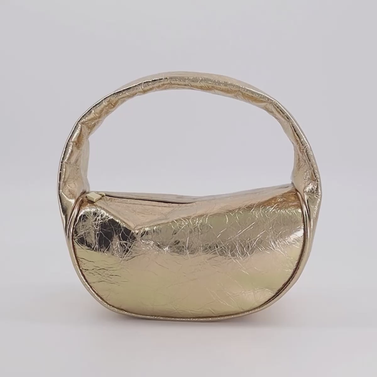 A rotating video of the mini bag featuring its U-shaped body connected by a single handle and a snippet of the bag's interior.